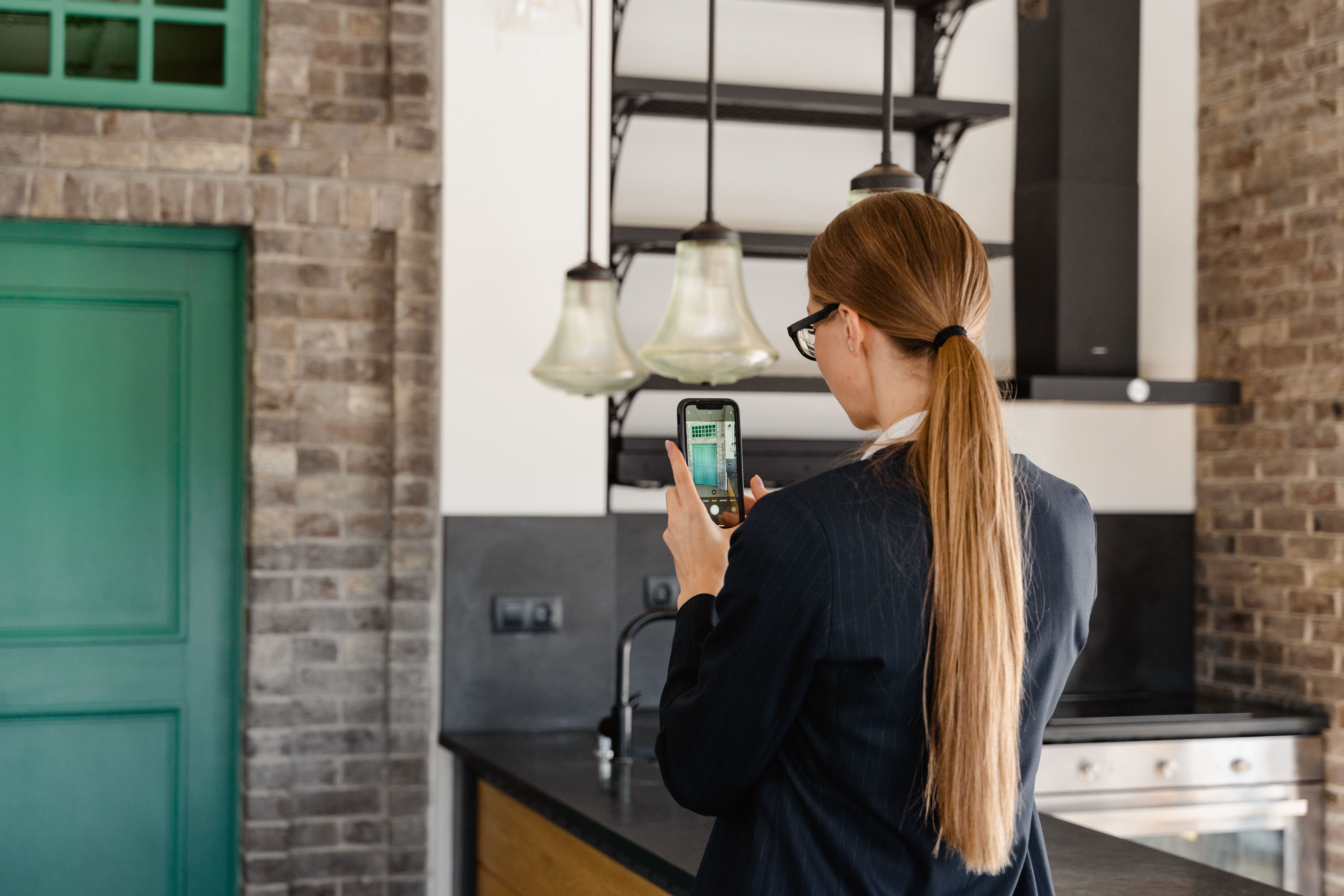 A person photographing an apartment kitchen with a phone